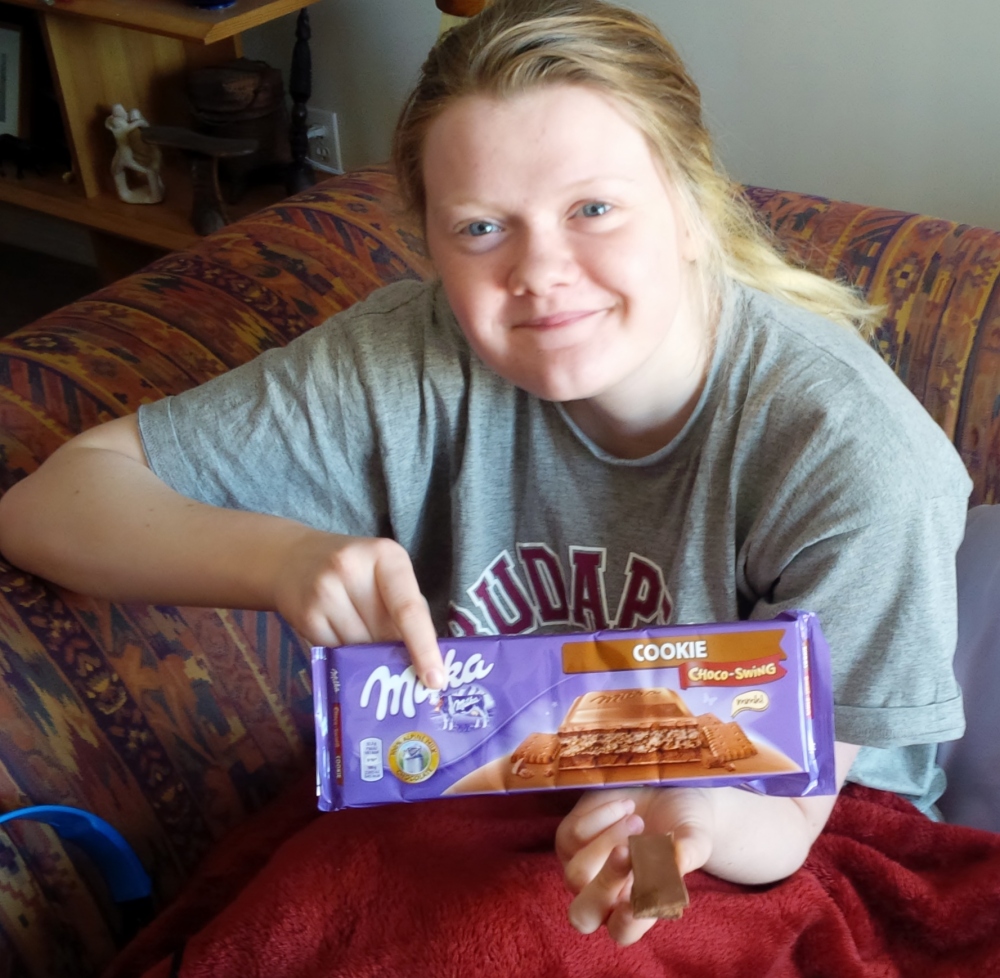 Jade returning home from her trip, eating her Milka - a great cure for jet lag!